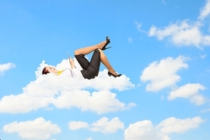 Businesswoman lying on clouds