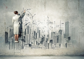 Businesswoman drawing on wall