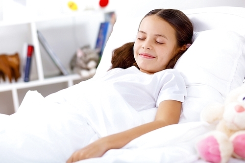 Little girl sleepng in her bed at home