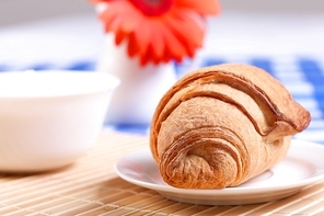 Continental breakfast with croissant on white plate