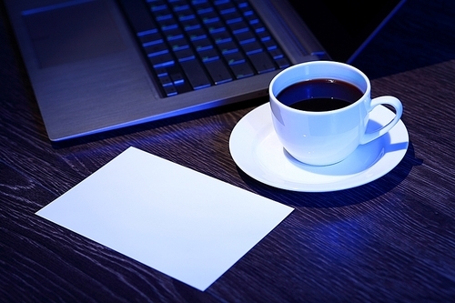 White cup with black coffee at business workplace