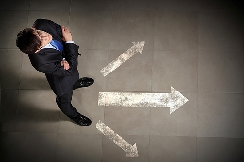 Top view of businessman standing against directions background