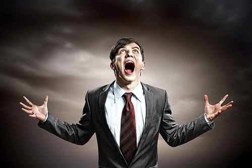 businessman in anger with fists clenched screaming