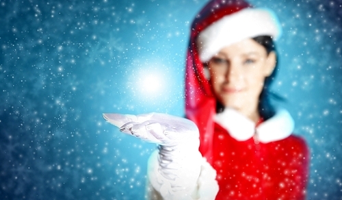 Portrait of beautiful girl wearing santa claus clothes on red background