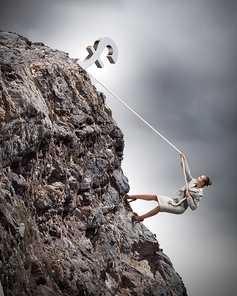 businesswoman climbing mountain hanging on rope pound on top
