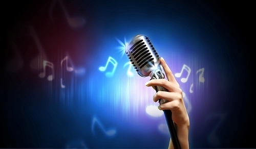 Single retro microphone against dark background with music notes