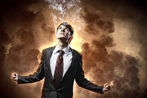 businessman in anger with fists clenched looking in the sky