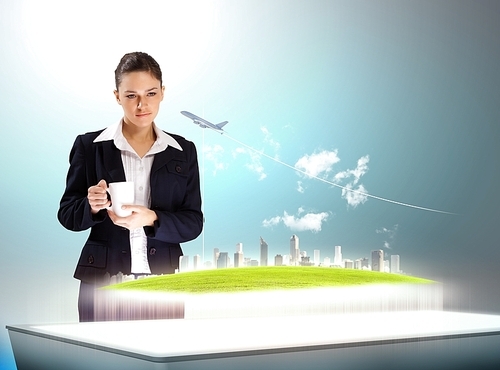 Image of young businesswoman holding cup standing against high-tech picture