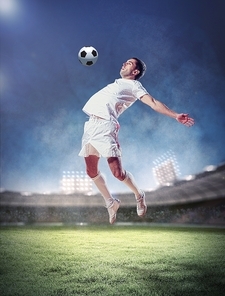 football player in white shirt striking the ball at the stadium