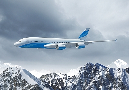 White passenger plane flying in the blue sky above the mountains with snow tops