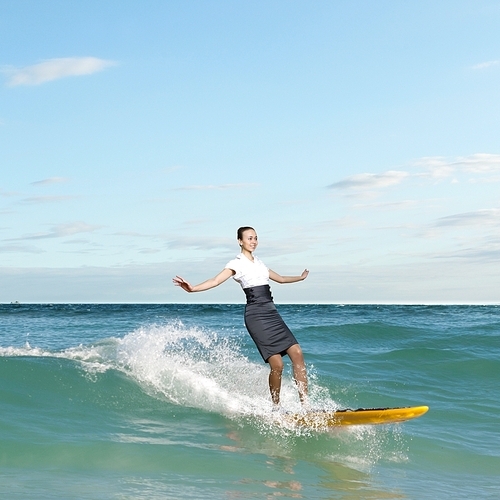 Image of young business person surfing on the waves of the ocean