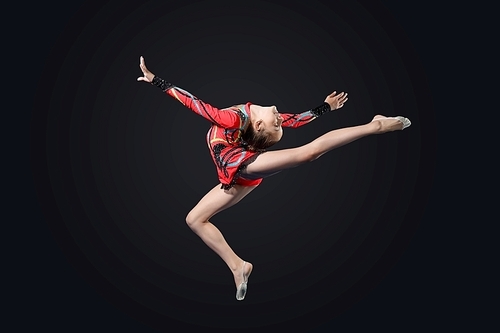 Young cute woman in gymnast suit show athletic skill on black background