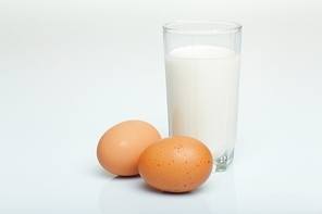 Milk in a glass jar and eggs on the table