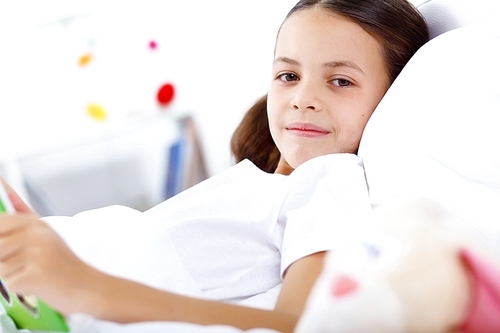 Portrait of girl with a book in bed at home