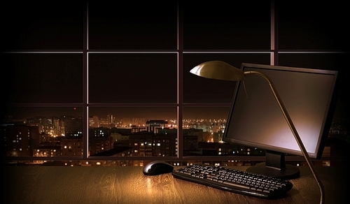 Work place in the office at night with a city view from window