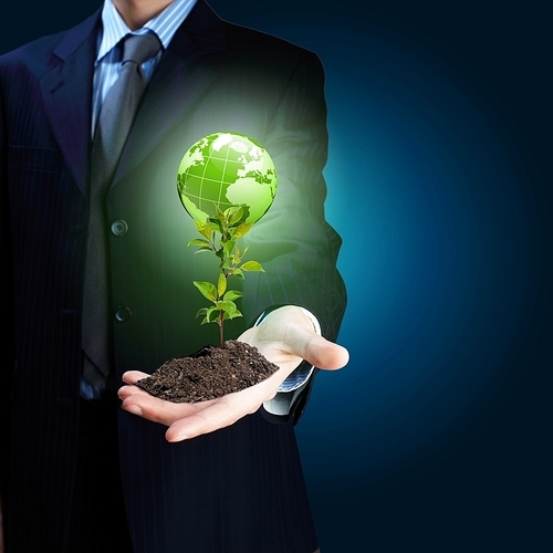 Young green plant in the hand of a businessman Elements of this image furnished by NASA.