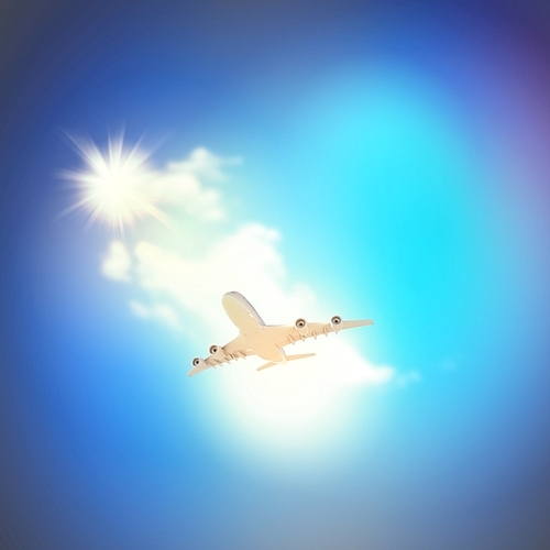 Image of flying airplane in clear sky with sun at background