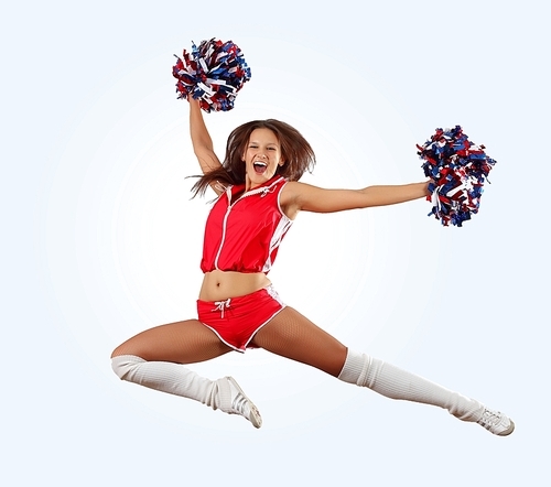 Uniformed cheerleader jumps high in the air   isolated on white.