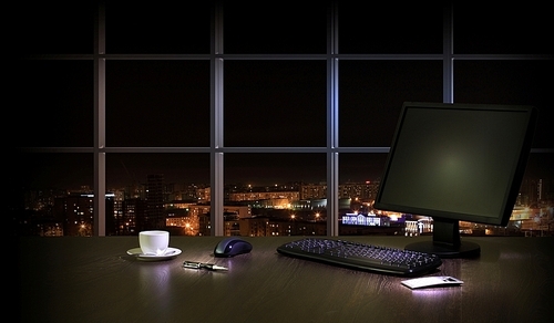 Work place in the office at night with a city view from window