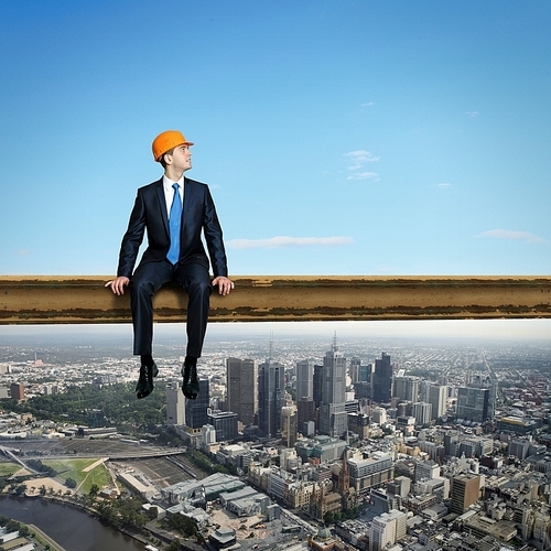 Business man standing high over a cityscape