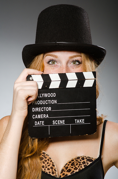 Woman with movie board wearing hat