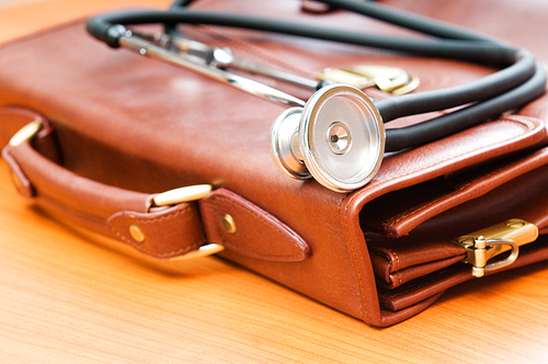 Doctor's case with stethoscope against wooden background
