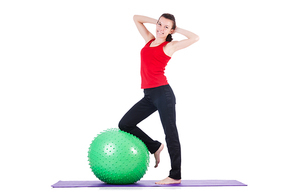 Young woman with ball exercising on white