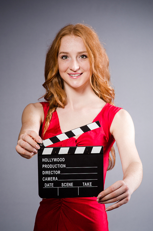 Woman in red dress with movie board