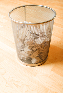 Garbage bin with paper waste isolated on white