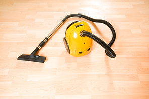 Vacuum cleaner on the polished wooden floor