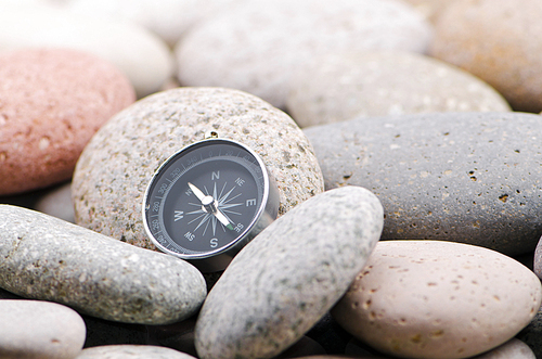 Navigation compass on stone pebbles