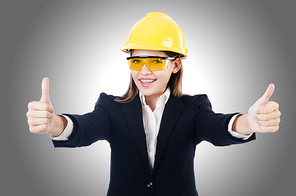 Young businesswoman with hard hat on white