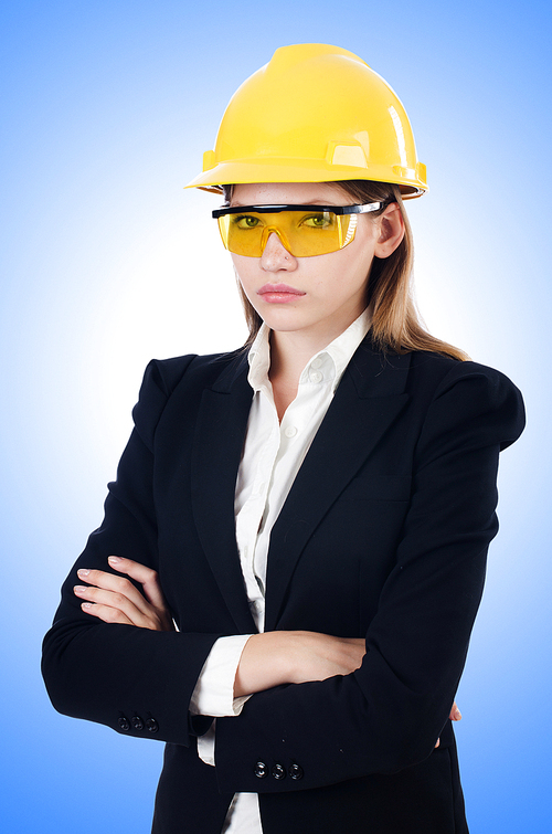 Young businesswoman with hard hat on white