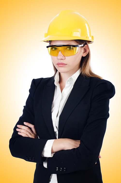 Young businesswoman with hard hat on white