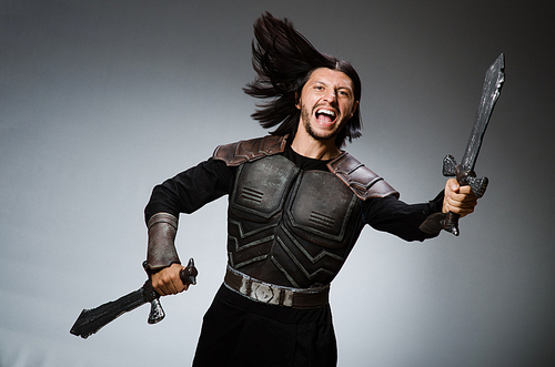 Angry knight with sword against dark background