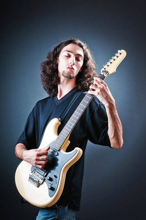 Guitar player against the dark background