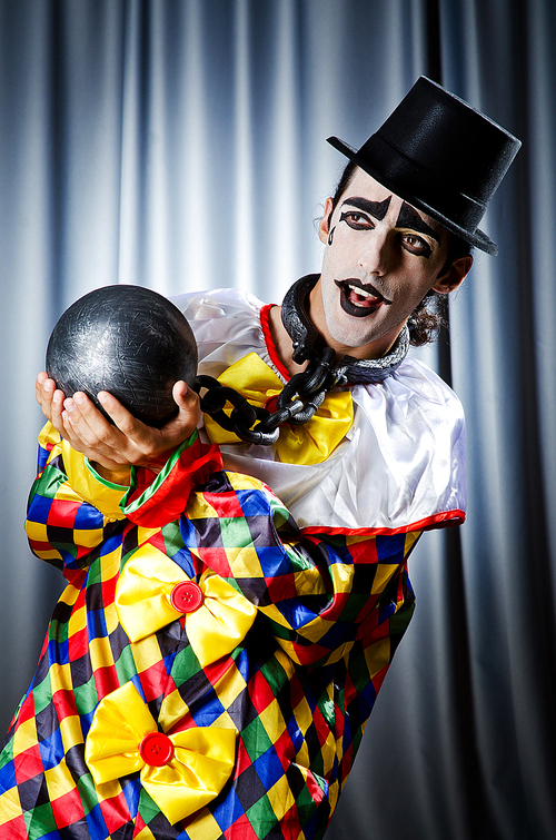 Clown with shackles in studio