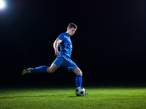 soccer player doing kick with ball on football stadium  field  isolated on  background
