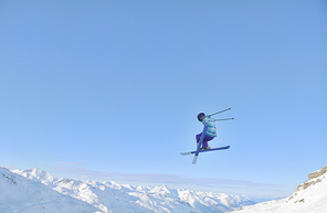 jumping freestyle skier at mountain with fresh snow fresh sunny winter day