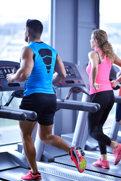 group of young people running on treadmills in modern sport  gym