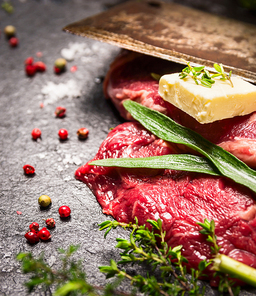 Raw beef Steak with fresh herbs,spices, butter and old cleaver