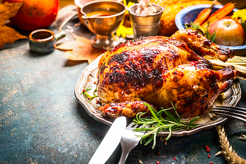 Roasted whole turkey or chicken on festive rustic table with festive autumn decoration for  Thanksgiving Day