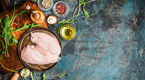 Raw Chicken breast and fresh ingredients for cooking on blue rustic background, top view, banner. Healthy, diet food or Sports nutrition concept.