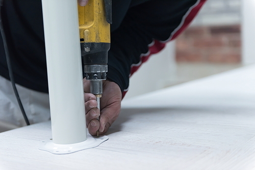 repairman working with drilling machine and assambling  furniture