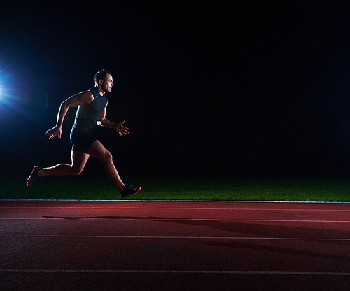 Sprinter leaving starting blocks on the running track. Explosive start.