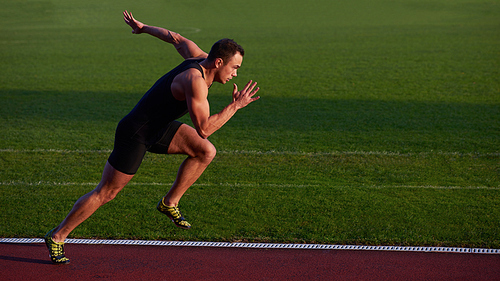 Sprinter leaving starting blocks on the running track. Explosive start.