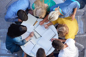 top view,  group of students together  at school table working homework and have fun