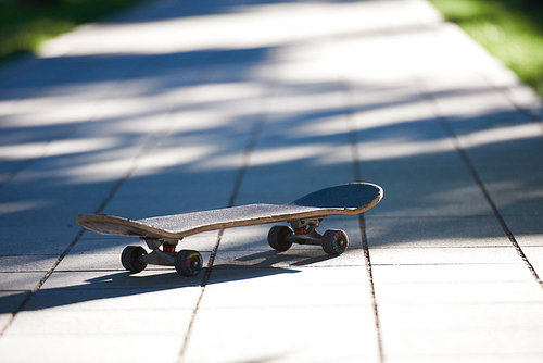 Old used skateboard isolated on the ground on street