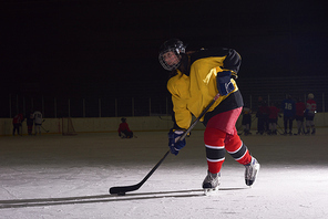 teen girl children ice hockey player in action kicking puck with stick