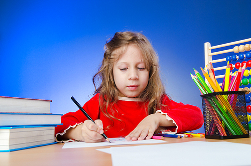 Little girl drawing with pencils